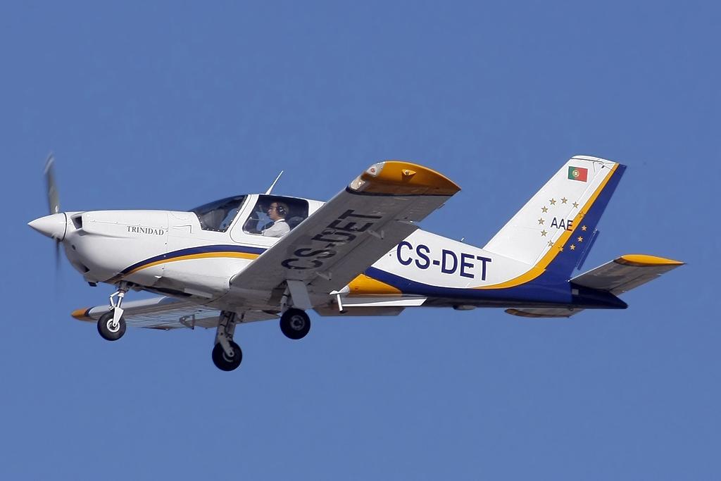 Socata TB-20 Trinidad single-engine aircraft in flight with landing gear extended